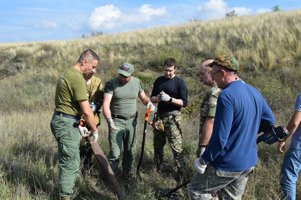 Участники отряда ведут поиск на местности с металлодетектором